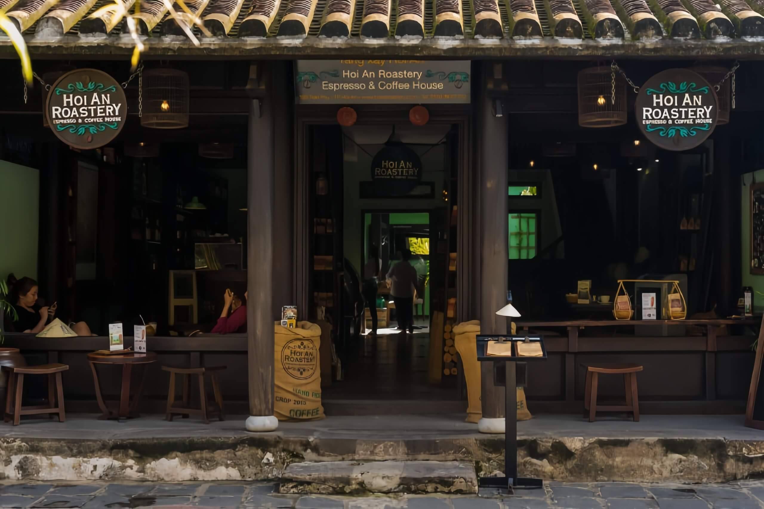 Mặt tiền gỗ của Hoi An Roastery trên phố Trần Phú, với biển hiệu tròn và bao cà phê ở lối vào